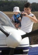 A man with a child takes pictures one of airplanes