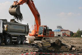 A power-shovel throws down earth in a truck
