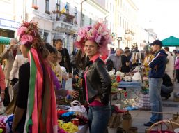 A girl measures a hat from flowers