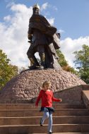 A girl hurries on a stair near a monument to the prince Mal