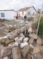 Місцевий жителі прибирають у дворі після урагану