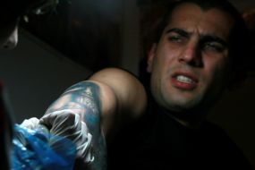 Participant of the festival makes a tattoo