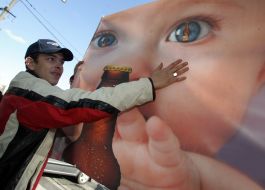 Baby with beer on a placard