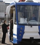 A man stands near tram