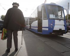An elderly man goes near tram
