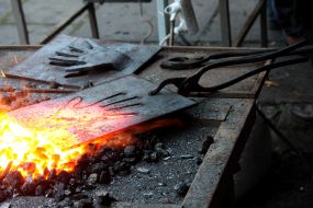 Кузнец накаливает металлическую пластину