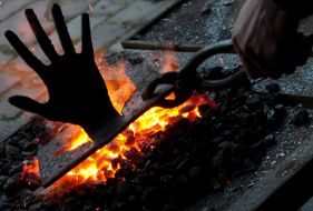 Кузнец накаливает металлическую пластину