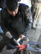 Кузнец выгибает металлическую руку