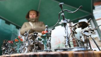 Женщина продает металлические изделия