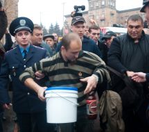 The employee of militia conducts the arrested participant of March UPA