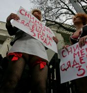 Активистки женского движения ”FEMEN” стоят с плакатами
