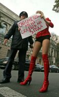 Активистка ”FEMEN” стоит возле милиционера