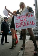 Активистки женского движения ”FEMEN” стоят с плакатами