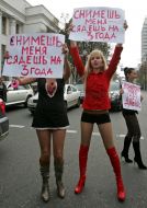 Активистки женского движения ”FEMEN” стоят с плакатами