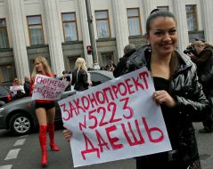 Активистки женского движения ”FEMEN” стоят с плакатами
