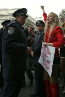 Активистки женского движения ”FEMEN” стоят с плакатами