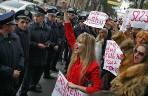 Активистки женского движения ”FEMEN” стоят с плакатами
