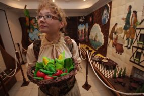 Співробітниця музею шоколаду тримає кошик з шоколаду