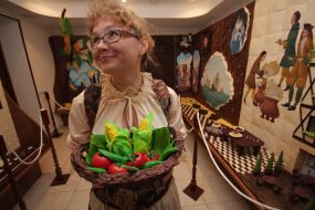 Співробітниця музею шоколаду тримає кошик з шоколаду