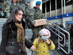 Mother with a child in a respirator mask go down on a stair