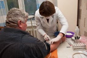 A doctor takes blood from a vein