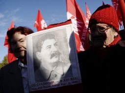 Elderly women hold the portrait of Stalin