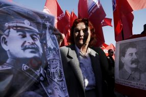 Elderly womens hold the portraits of Stalin