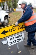 A worker sets a sign-board