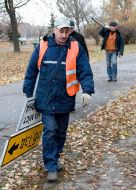 A worker sets a sign-board