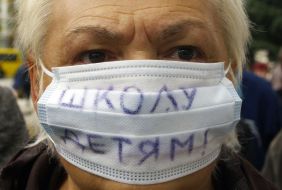 Участница митинга-пикета в респираторной маске