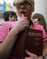 The ”FEMEN” womanish motion activist holds a textbook