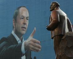 Placard with representing Sergey Tigipko near a monument to Lenin