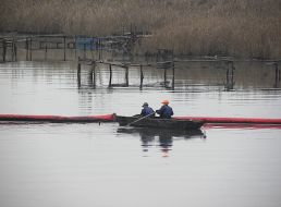 Workers place the booms barrages