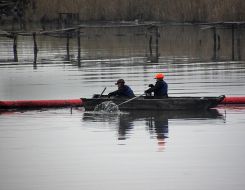 Workers place the booms barrages