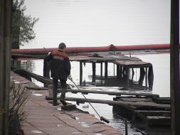 A worker draws fuel oil from Kalmius river