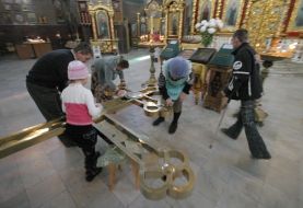 Parishioners wash a cross