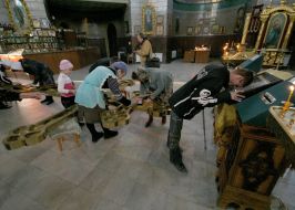 Parishioners wash a cross