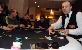 A croupier distributes cards to the players