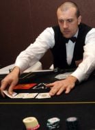 A croupier distributes cards to the players