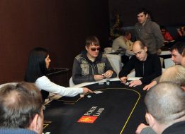 A croupier distributes cards to the players