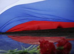 Гвоздики под растянутым флагом Российской Федерации