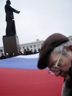 Мужчина стоит возле флага РФ