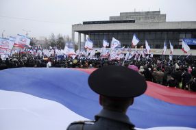 Милиционер стоит возле флага РФ