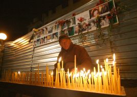 Мужчина зажигает свечу