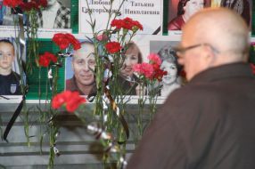 Мужчина рассматривает фотографии жертв взрыва