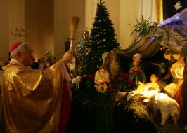 Священослужитель кропить святою водою різдвяний вертеп