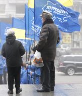 Passer-by with a boy near the supporters of Party of regions