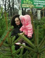 Mother with a child on one of fir-trees markets