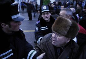 Сотрудник милиции задерживает пожилого мужчину