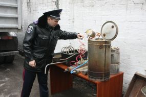 The employee of militia demonstrates hootch still